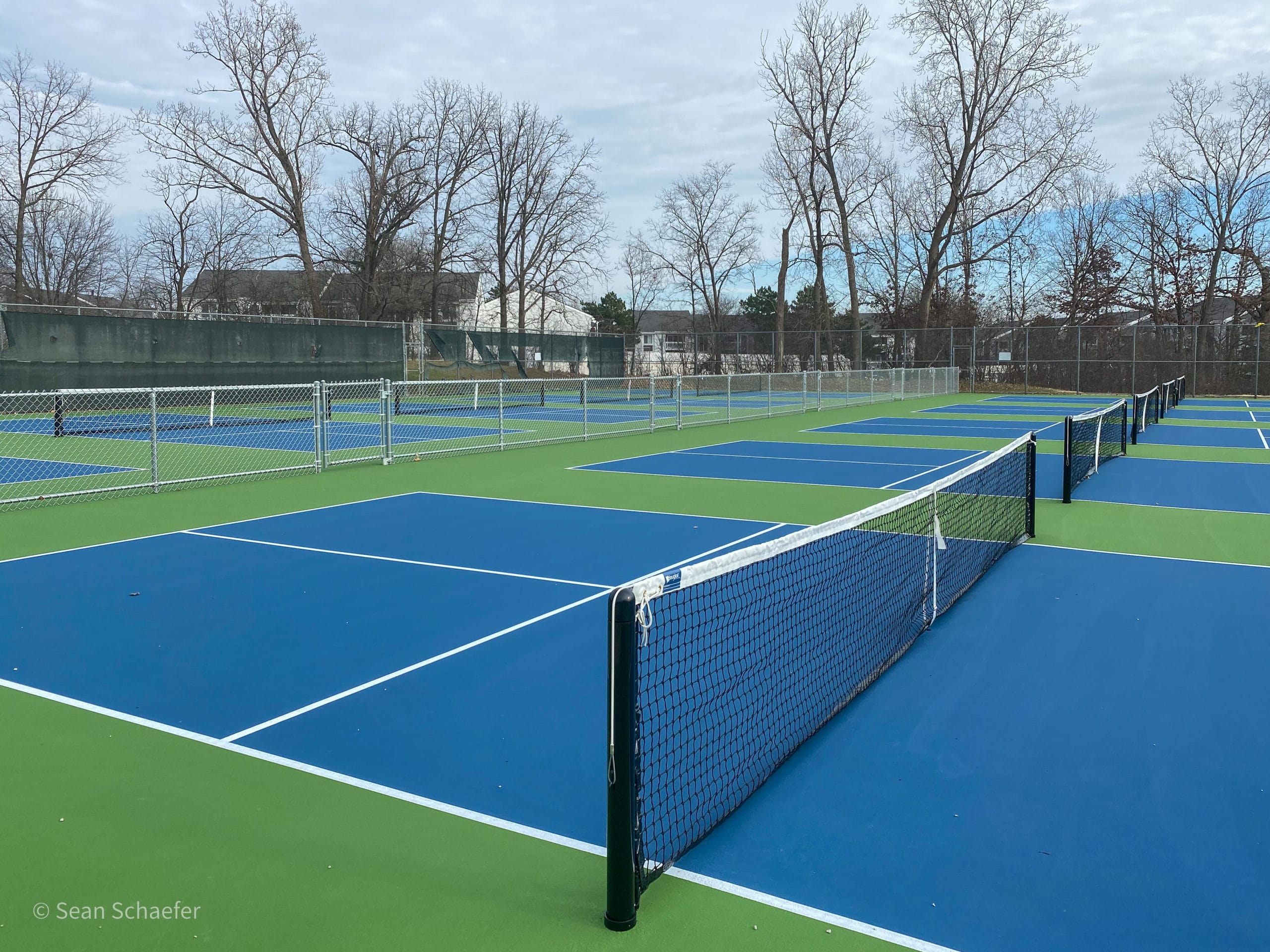 Image of new pickle ball courts, commercial chain link fencing, nets, and posts in Metro Detroit, Michigan