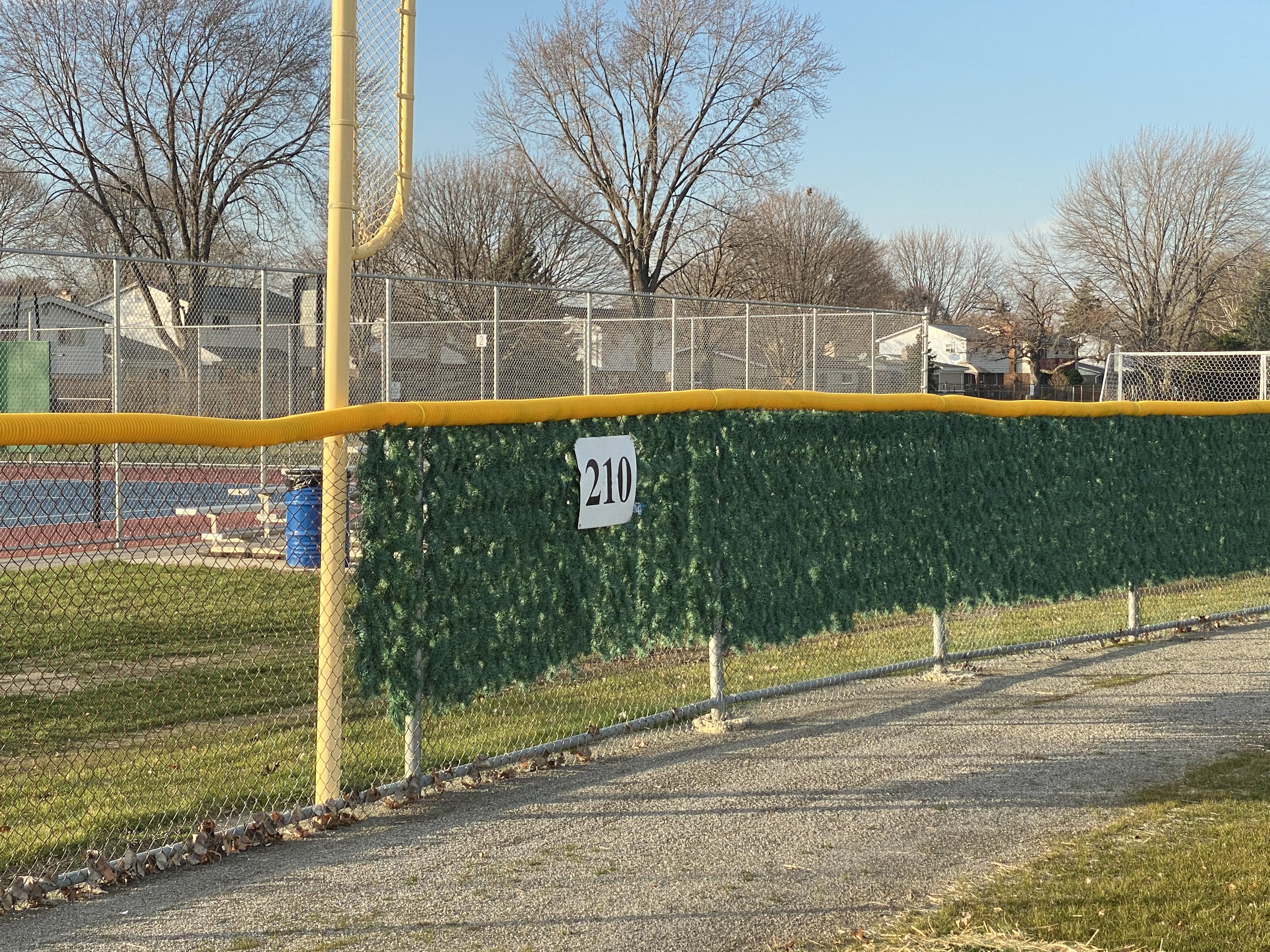 Image of commercial chain link baseball diamond fencing, PVC top cap, and Christmas tree slats at Cousino High School